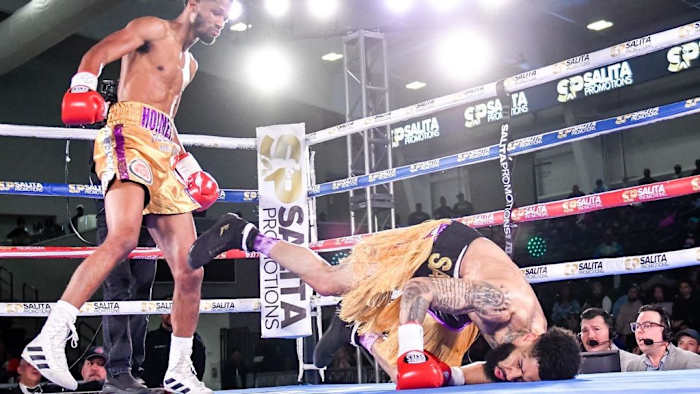 Ardreal Holmes Jr. (gold trunks) knocks down Marlon Harrington (black and gold trunks) in the second round of their USBA super welterweight championship fight at the Wayne State Filed House in Detroit, Michigan. GREGORY SHAMUS/GETTY IMAGES.